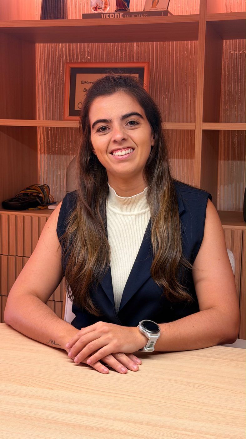 Amanda Toledo, fisioterapeuta, sentada à mesa no consultório